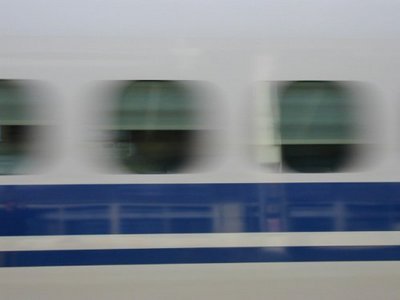 Shinkansen train passing a station at high speed